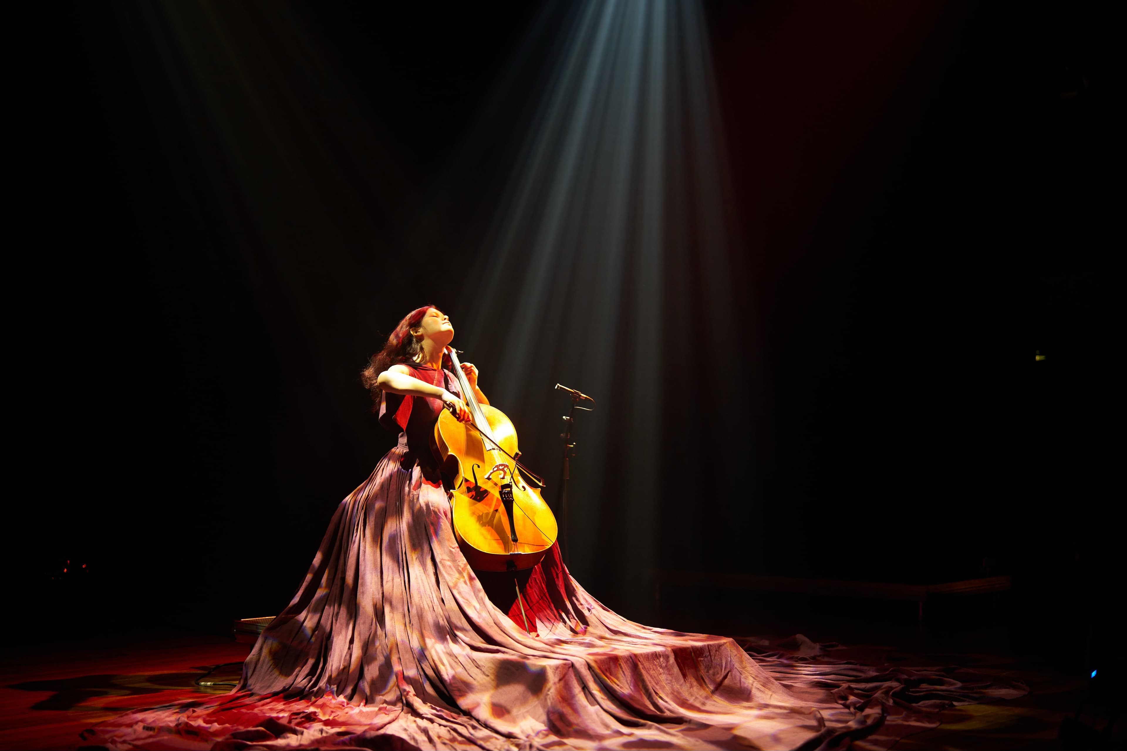 Maya Fridman plays cello on a podium